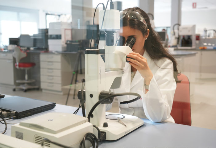 a chemist examines a polypropylene pellet through a microscope